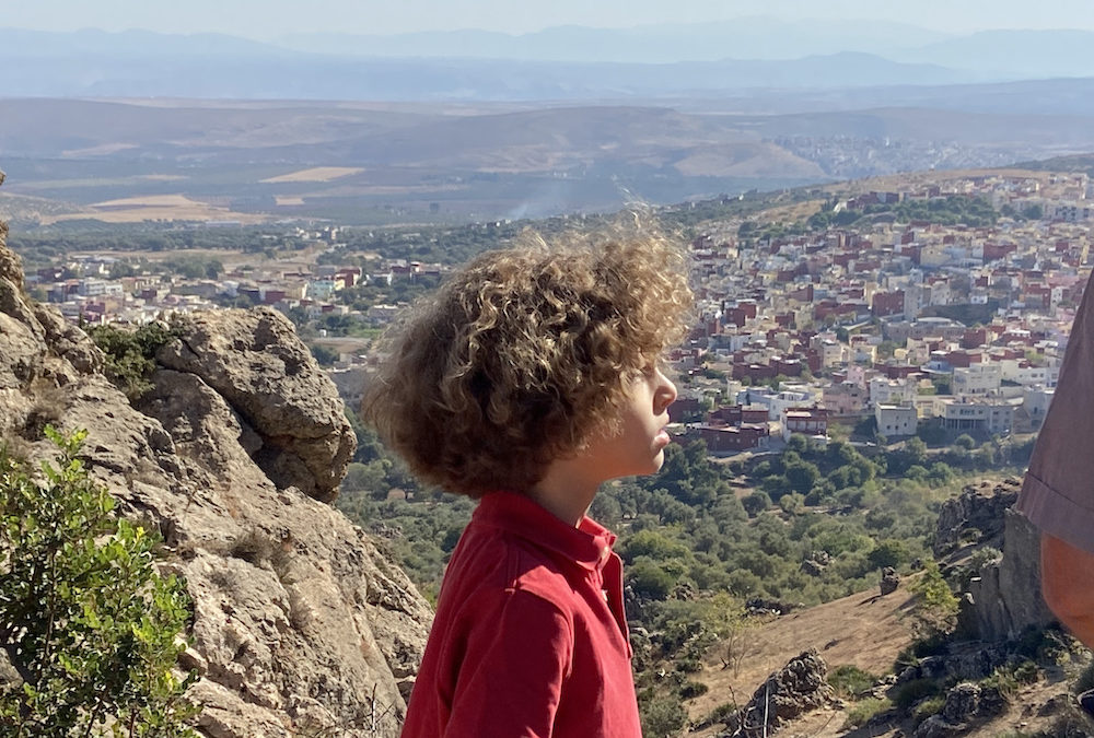 Enfant surplombant les coteaux du Moyen Atlas au Maroc
